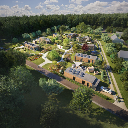 Oversigtsbillede af en lodgeside med moderne hytter, haveanlæg og grønne omgivelser ved en skov.