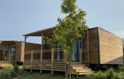 Houten huisjes met veranda en trappen bij Cottage in Domaine Seasonova Saâne et Mer, Frankrijk in de zomer.