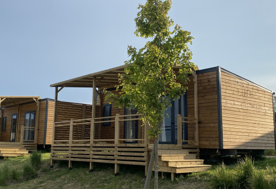 Cabañas de madera con porche y escalones en Cottage de Domaine Seasonova Saâne et Mer, Francia, en verano.