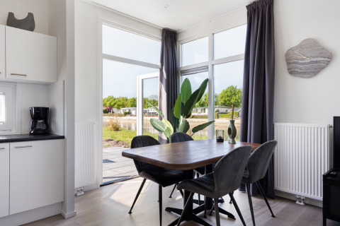 Moderne eethoek in Turfsteker Chalet bij De Tien Heugten in Nederland met zicht op de buitenomgeving.