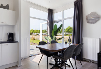 Moderne eethoek in Turfsteker Chalet bij De Tien Heugten in Nederland met uitzicht op de natuur buiten.