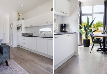 Cucina moderna e zona pranzo al Turfsteker Chalet di De Tien Heugten, Paesi Bassi, con arredi chiari.