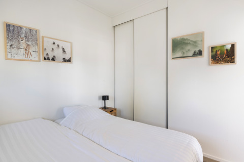 Schlafzimmer im Turfsteker Chalet bei De Tien Heugten, Niederlande, mit Doppelbett und Wandbildern.