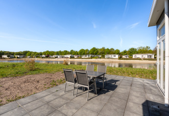 Outdoor patio at Turfsteker Chalet, De Tien Heugten in the Netherlands, overlooking pond and chalets.