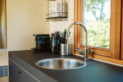 Moderne kitchenette met spoelbak en raam in tiny house Klapkot C20, Holiday park De Klepperstee, Nederland.