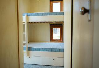 Zicht op een kleine kamer met stapelbed en twee ramen in tiny house Klapkot C20 op De Klepperstee.