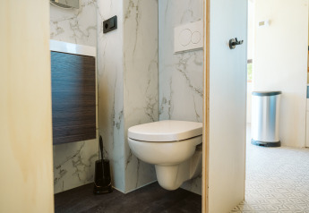 Bagno moderno con wc sospeso e decorazione in marmo nella tiny house Klapkot C20 a De Klepperstee, Paesi Bassi.