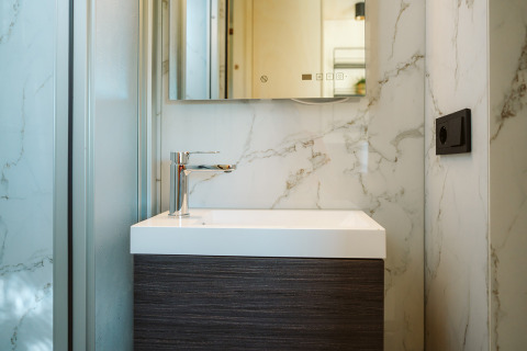 Modernes, kompaktes Badezimmerwaschbecken mit Marmordetails in einem Tiny House im De Klepperstee, Niederlande.