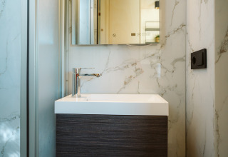 Modern, compact badkamermeubel met marmerdetails in een tiny house op De Klepperstee, Nederland.