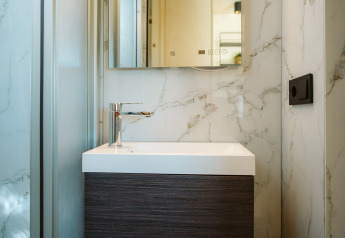 Lavabo de salle de bain moderne et compact avec détails en marbre dans une tiny house à De Klepperstee, Pays-Bas.