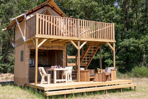 Twee verdiepingen hoge houten hut met balkon in Domaine Bonneblond, Auvergne-Rhône-Alpes, Frankrijk.