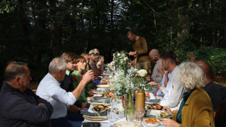 Invitados disfrutan de una comida al aire libre en el bosque en Domaine Bonneblond, Auvergne-Rhône-Alpes, Francia.