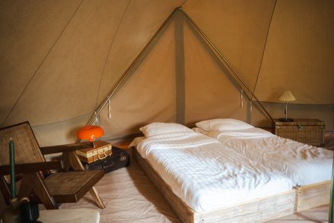 Knusse tentinrichting op Domaine Bonneblond in Auvergne-Rhône-Alpes, Frankrijk, met twee bedden en vintage meubels.