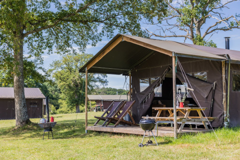Luxe tentkamperen op Domaine Bonneblond met houten terras en barbecue in Auvergne-Rhône-Alpes, Frankrijk.