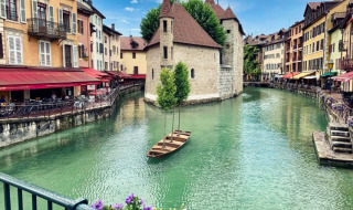 Vista pintoresca de un canal con casas coloridas y una fortaleza medieval en Annecy, Auvergne-Rhône-Alpes, Francia.