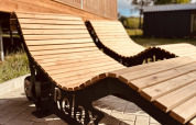Houten ligzetels met het woord 'Relax' bij Lakehouse Scandi aan Wilsumer Berge in Duitsland, zonnige dag.