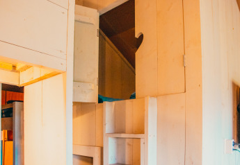 Intérieur d'une tente safari avec murs en bois et rangements au parc De Boshoek, Pays-Bas.