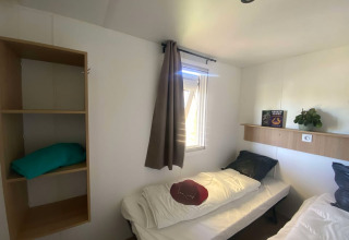 Chambre du Prestige Cottage au Domaine Seasonova Saâne et Mer, France, avec deux lits simples et étagère.