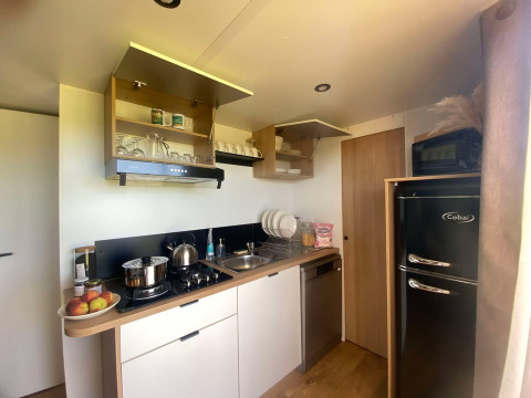 Cocina moderna en la cabaña de Domaine Seasonova Saâne et Mer en Francia, con armarios abiertos y frigorífico.