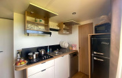 Moderne keuken in het Cottage van Domaine Seasonova Saâne et Mer in Frankrijk met open kasten en koelkast.