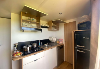 Cucina moderna nel Cottage al Domaine Seasonova Saâne et Mer in Francia, con mobili aperti e frigorifero nero.