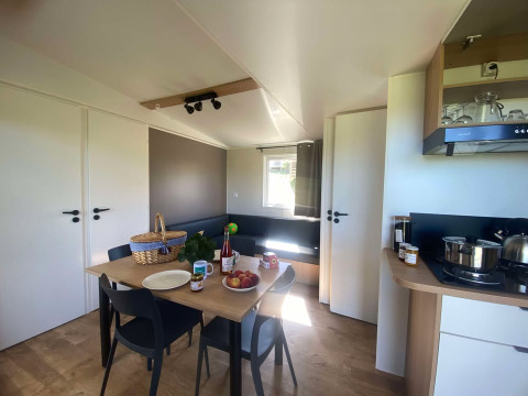 Modernes Cottage im Domaine Seasonova Saâne et Mer, Frankreich, mit Essbereich und Küchenzeile.