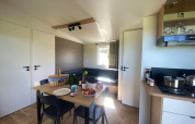 Modern lodge Cottage at Domaine Seasonova Saâne et Mer in France, featuring a dining table and kitchenette.