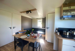 Modern lodge Cottage at Domaine Seasonova Saâne et Mer in France, featuring a dining table and kitchenette.