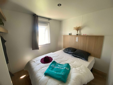 Dormitorio en una cabaña de Domaine Seasonova Saâne et Mer, Francia, con cama doble y luz natural.