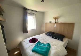 Dormitorio en una cabaña de Domaine Seasonova Saâne et Mer, Francia, con cama doble y luz natural.