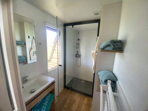 Moderne badeværelse i Cottage på Domaine Seasonova Saâne et Mer i Frankrig med bruser og håndklæder.