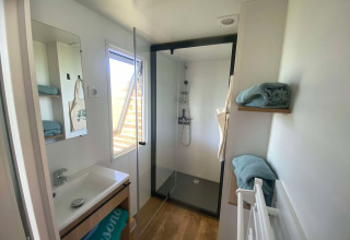 Moderne badkamer in Cottage bij Domaine Seasonova Saâne et Mer in Frankrijk met douche en handdoeken.