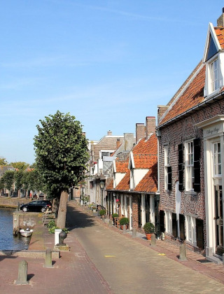 Un pittoresco canale e una strada acciottolata con case storiche vicino a Hasselt, Overijssel, Paesi Bassi.