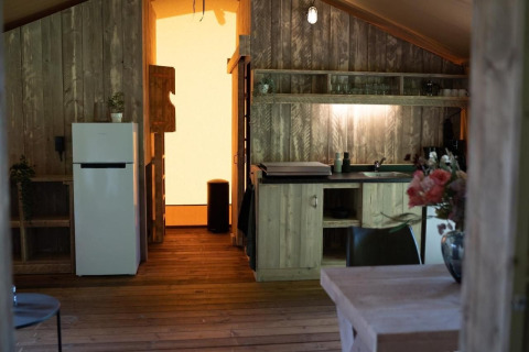 Binnenkant van Glampingtent Lina bij Glamping Franse Peer in Nederland, houten keuken en bloemenvaas.