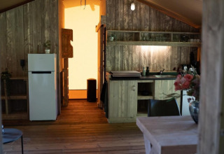 Binnenkant van Glampingtent Lina bij Glamping Franse Peer in Nederland, houten keuken en bloemenvaas.