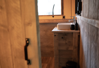 Interior de madera y lavabo moderno en el baño de Glampingtent Lina en Glamping Franse Peer, Países Bajos.