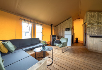 Interno della Glampingtent Lina con arredi moderni presso Glamping Franse Peer nei Paesi Bassi, di giorno.