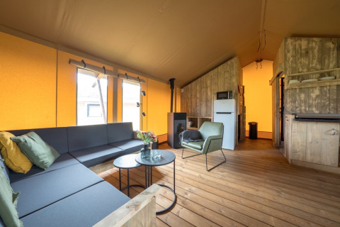 Interieur van Glampingtent Lina met moderne inrichting bij Glamping Franse Peer in Nederland, overdag.