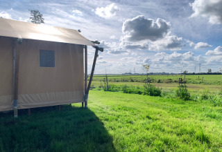 Tenda glamping al Glamping Franse Peer, Overijssel, Paesi Bassi, con vista su prati verdi e cielo nuvoloso.