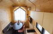 Cozy, modern tiny house interior at Camping Vinkenhof in the Netherlands, featuring wood paneling and seating.