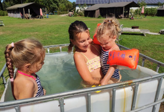 Kinderen spelen in een klein zwembadje bij Feather Down De Brabantse Hei in Noord-Brabant, Nederland.