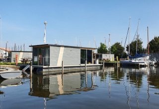 Casa galleggiante e barche alla Marina Heeg, villaggio vacanze in Frisia, Paesi Bassi, in una giornata di sole.