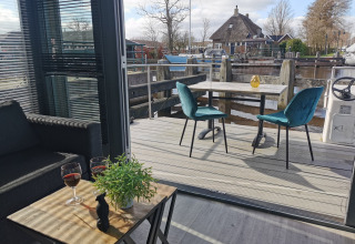 Gezellig terras aan Marina Heeg vakantiepark in Friesland, Nederland, met zicht op het water en boten.