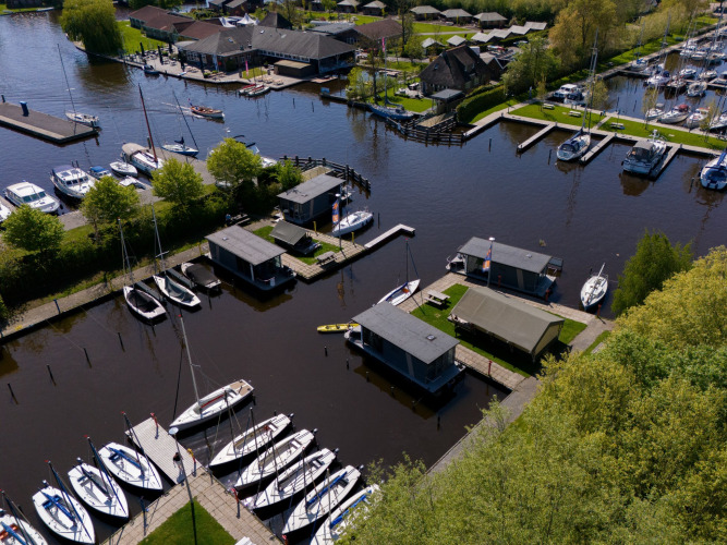 Luchtfoto van vakantiepark Marina Heeg in Friesland, Nederland, met boten, huisjes en waterwegen.