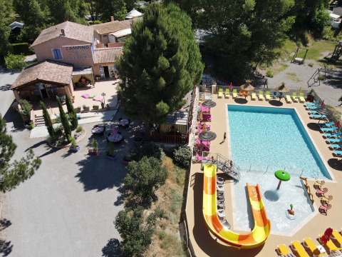 Vista aérea de Flower Camping La Rivière con piscina, toboganes y tumbonas en la Provenza, Francia.