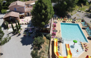 Vista aerea del Flower Camping La Rivière con piscina, scivoli e lettini prendisole in Provenza, Francia.
