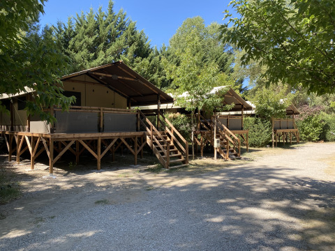Tiendas glamping en plataformas de madera rodeadas de árboles en Flower Camping La Rivière, Provenza-Alpes-Costa Azul.