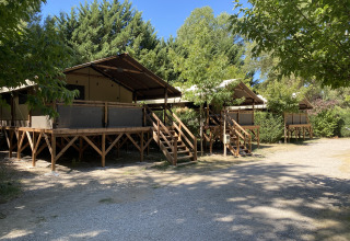 Op houten platforms gebouwde glamping tenten tussen bomen bij Flower Camping La Rivière, Provence-Alpes-Côte d’Azur.