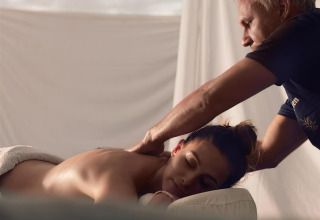 Kvinde nyder afslappende massage i solen på Flower Camping La Rivière-feriepark i Provence-Alpes-Côte d’Azur.
