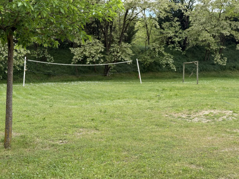 Buitensportveld bij Flower Camping La Rivière in Provence met volleybalnet en voetbaldoel in het gras.